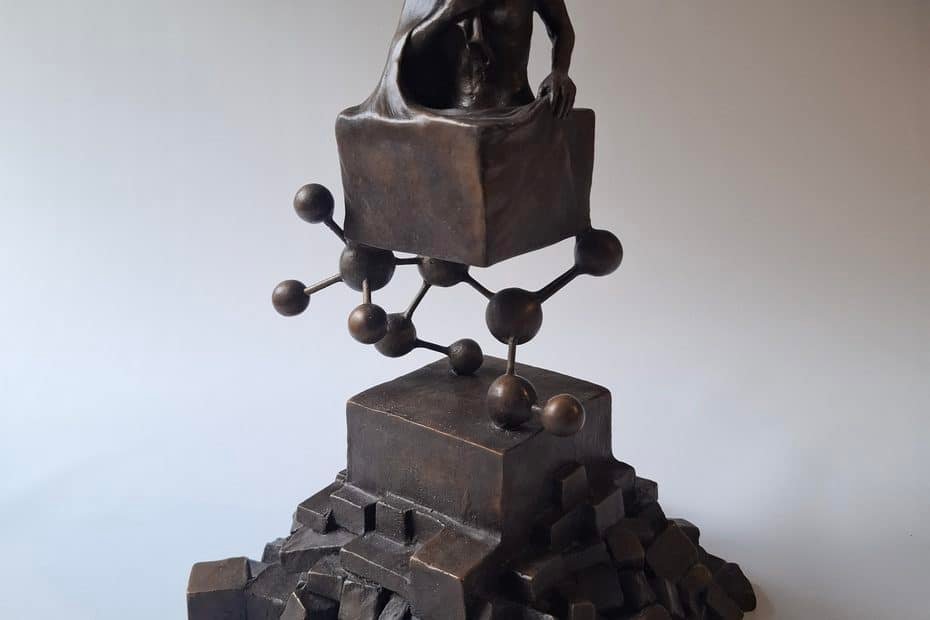 • LabNews AI Bronze sculpture of a shirtless man seated on a cube with a molecular like chain of spheres and rods below on a stepped base